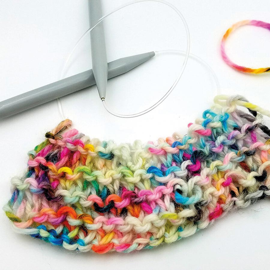 Jacquard Acid Dye Textilfarbe für Wolle und Seide Strickstück aus bunt gefärbter Wolle an einer Rundstricknadel