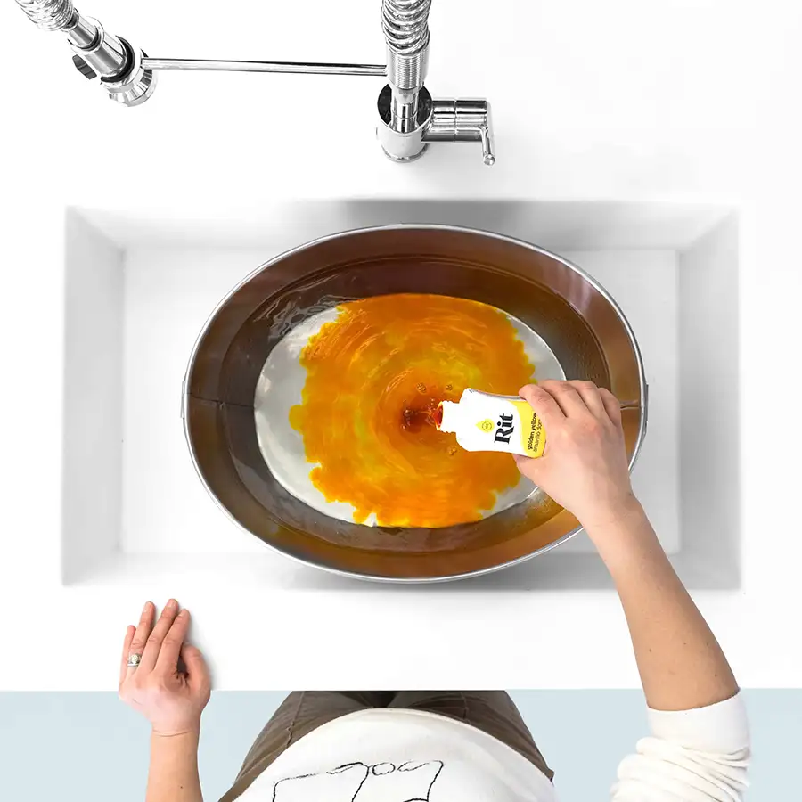 Rit All-Purpose Dye Universal Textilfarbe Rit All-Purpose Dye wird in eine Schüssel mit Wasser im Spülbecken gegossen